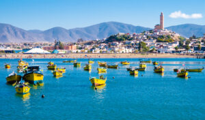 Boats in a bay with city and mountains behind