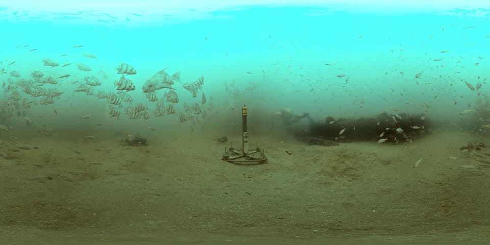 Image of a hydrophone on the seafloor surrounded by schools of fish. The hydrophone is a cylindrical instrument that sits vertically on a wide, X-shaped base.