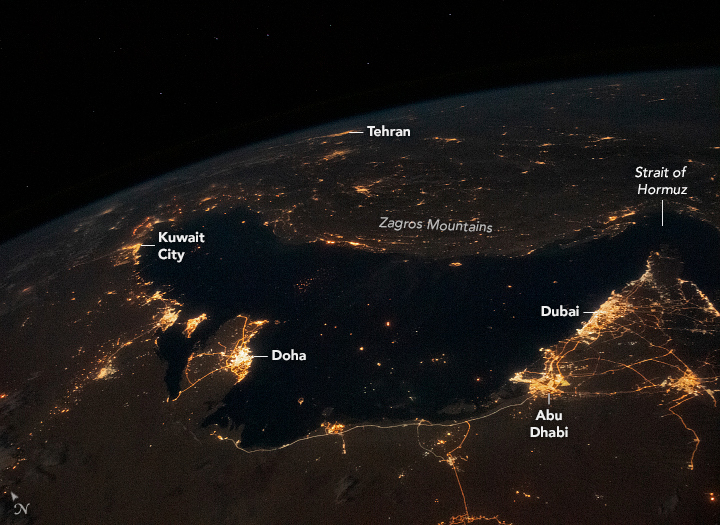A nighttime image of the Arabian Gulf from space. Major cities are visible bright spots along the peninsula.